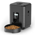 Automatic pet feeder with LCD timer display and removable food bowl filled with dry kibble